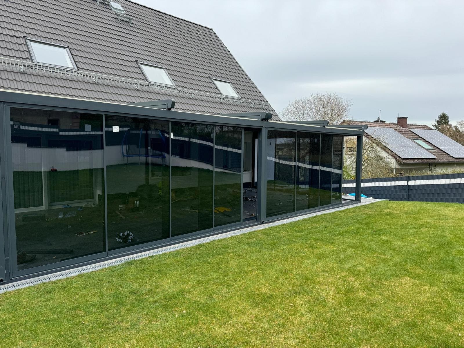 Glasumrandung mit Glasschiebewänden über Eck