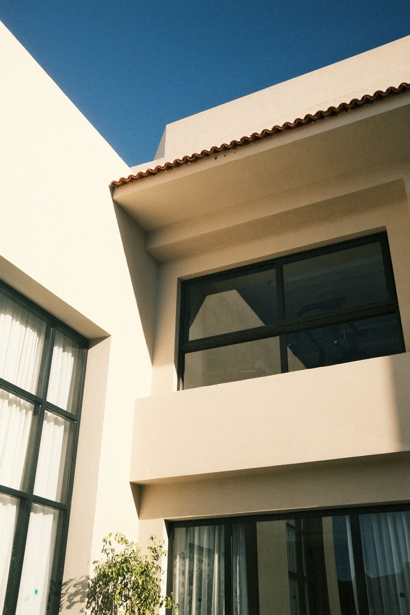 Moderne Fenster mit dunklen Rahmen an einem hellen Haus